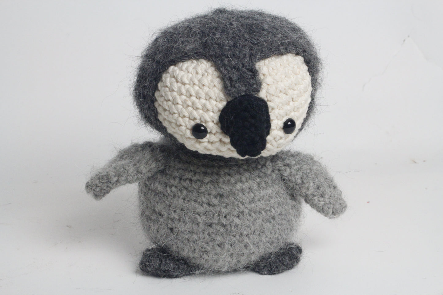 Crocheted penguin toy on a white background