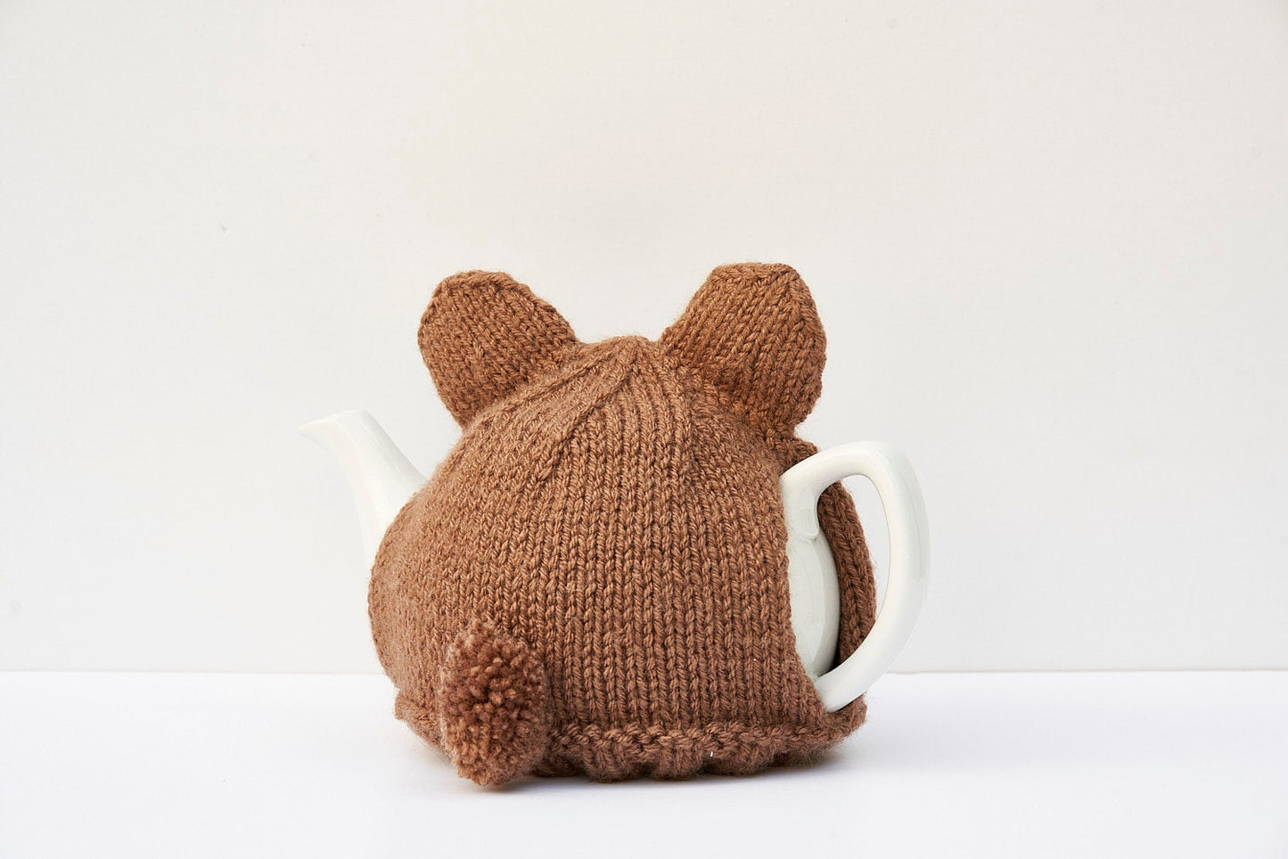 Knitted brown bear tea cosy with pom pom tail. Washable fits 1 litre teapot.