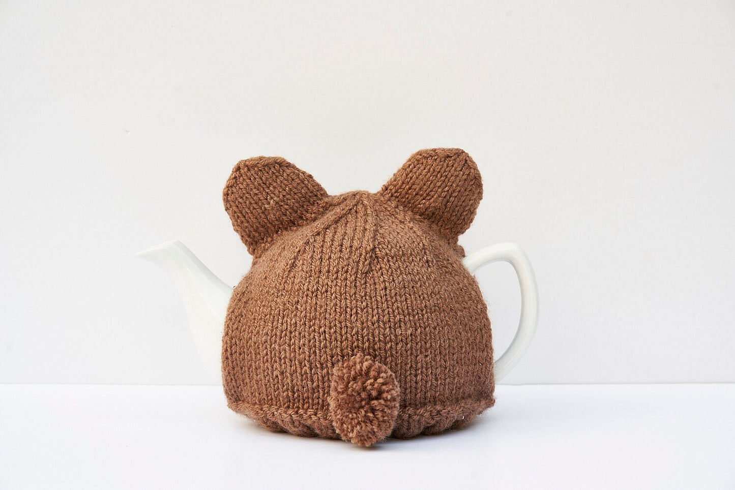 Knitted brown bear tea cosy with pom pom tail. Washable fits 1 litre teapot.
