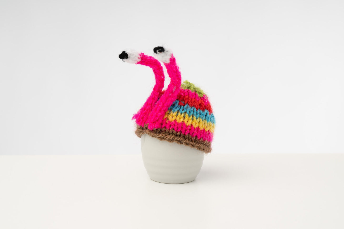 Knitted pink stripy snail tea cosy. Tea lovers teatime treat.