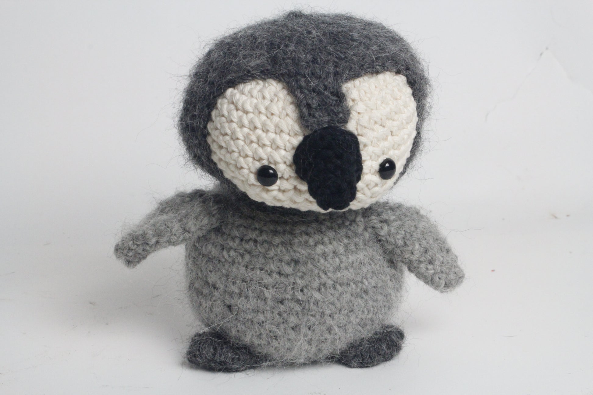 Crocheted penguin toy on a white background