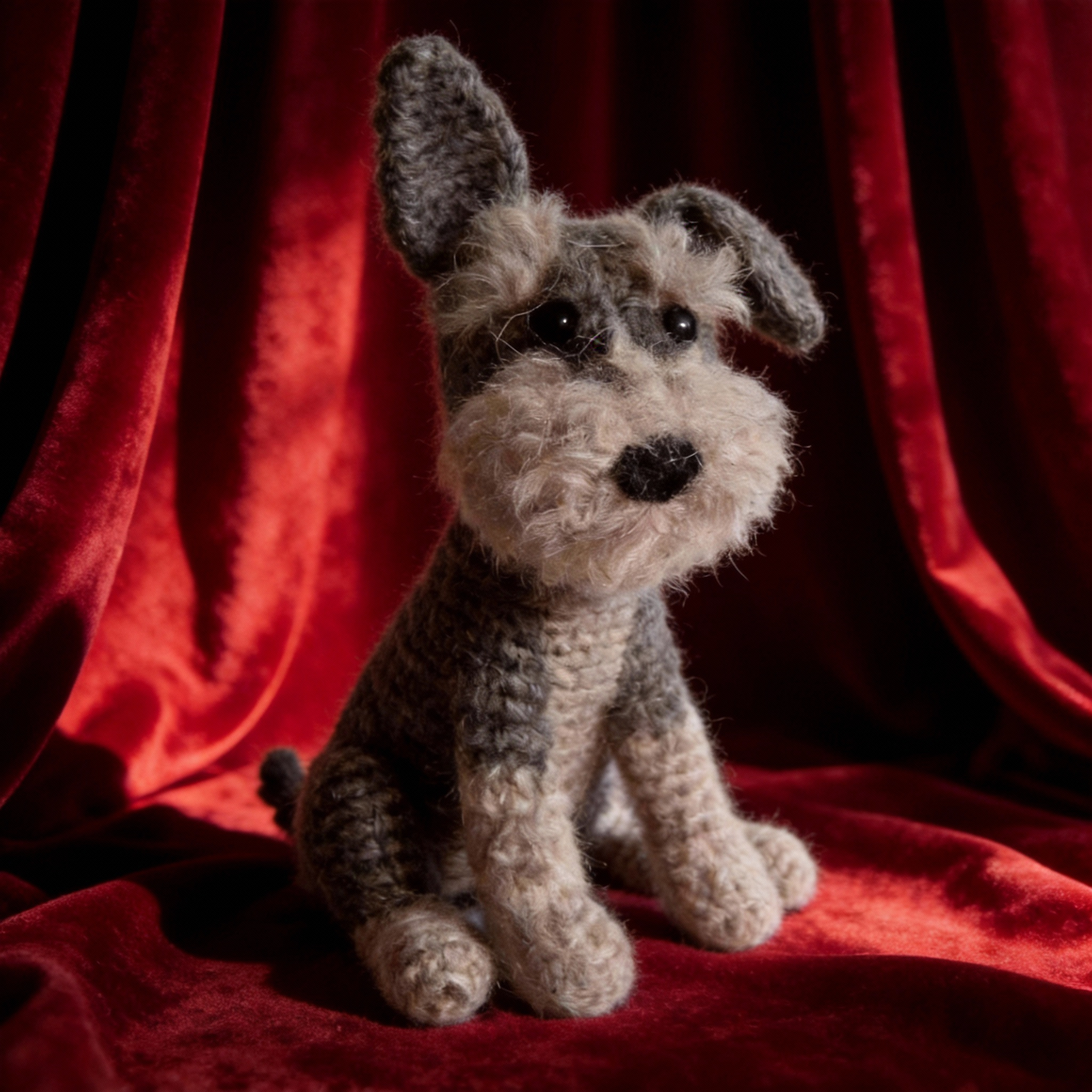 Crochet Schnauzer dog toy on a red fabric background
