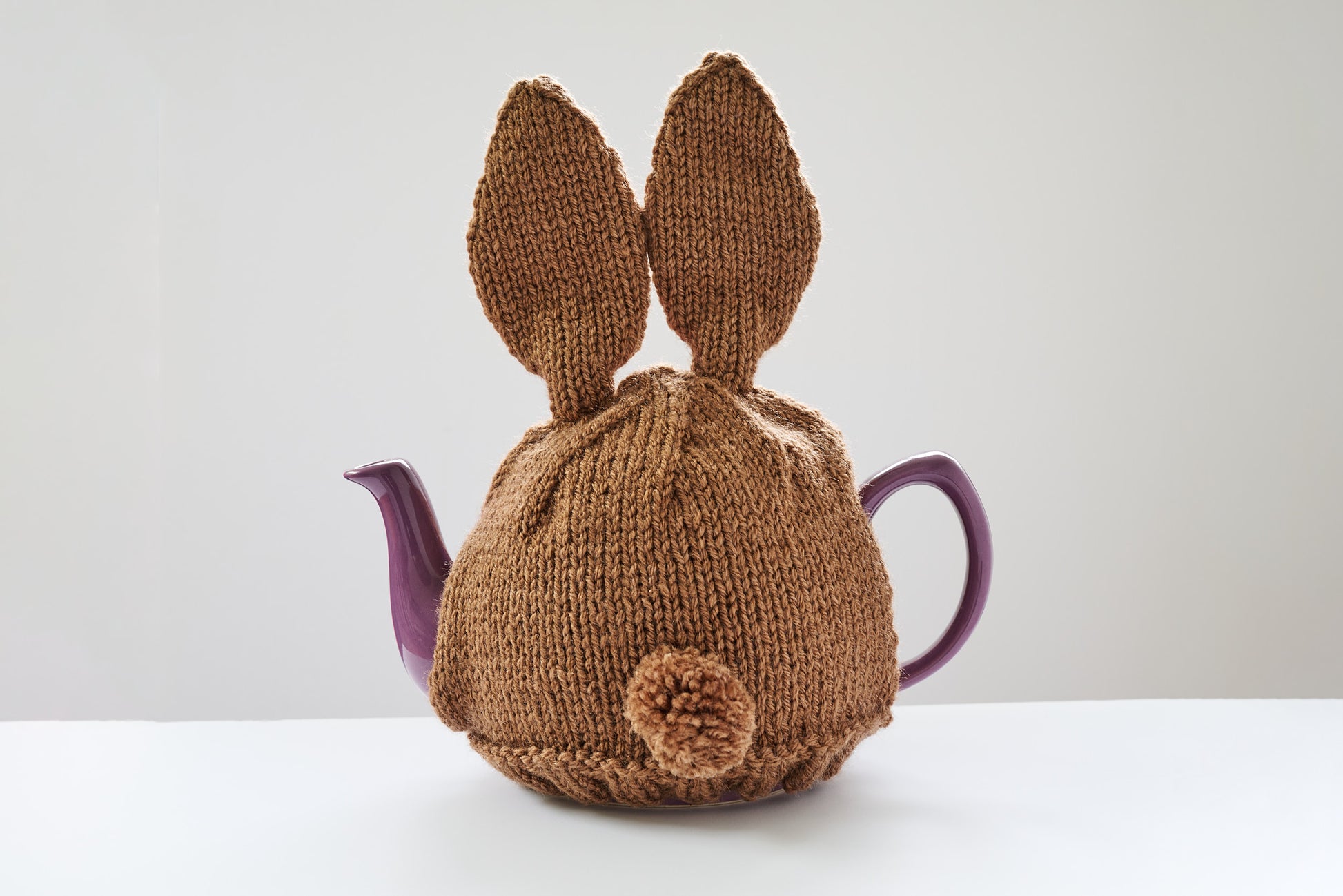 Hand knitted bunny rabbit tea cosy with pom pom bottom.