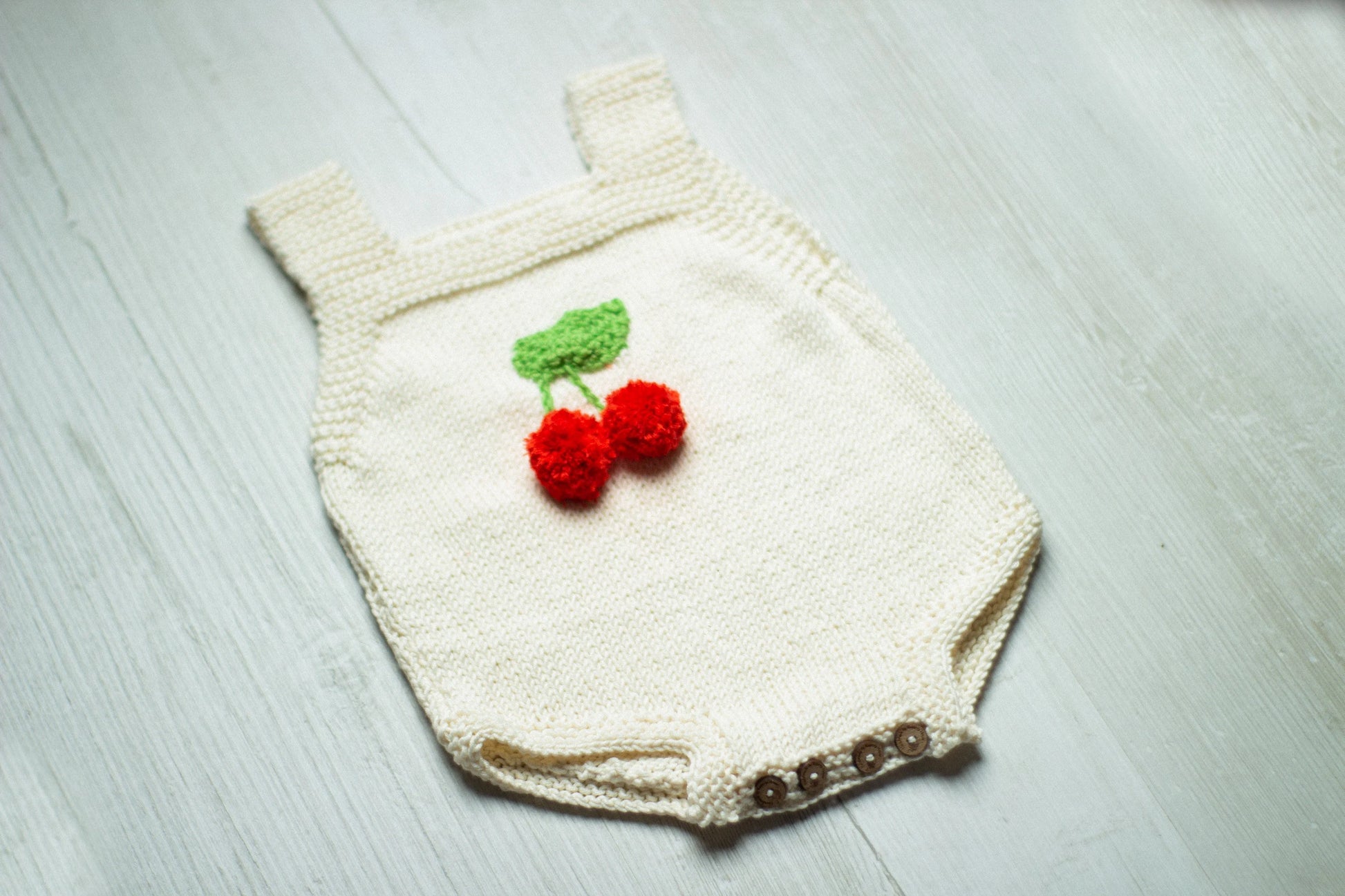Knitted baby romper with cherry design 