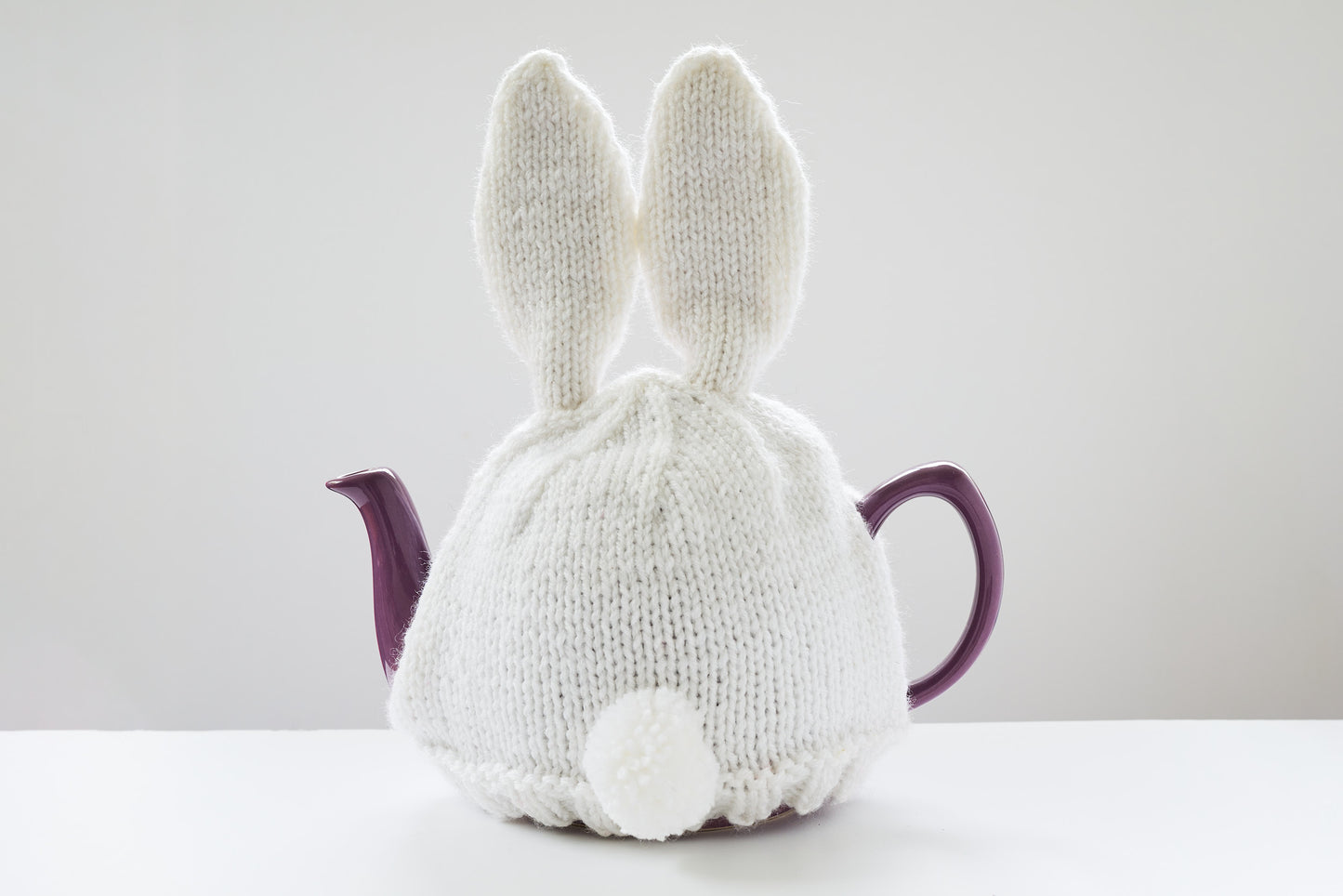 Hand knitted bunny rabbit tea cosy with pom pom bottom.