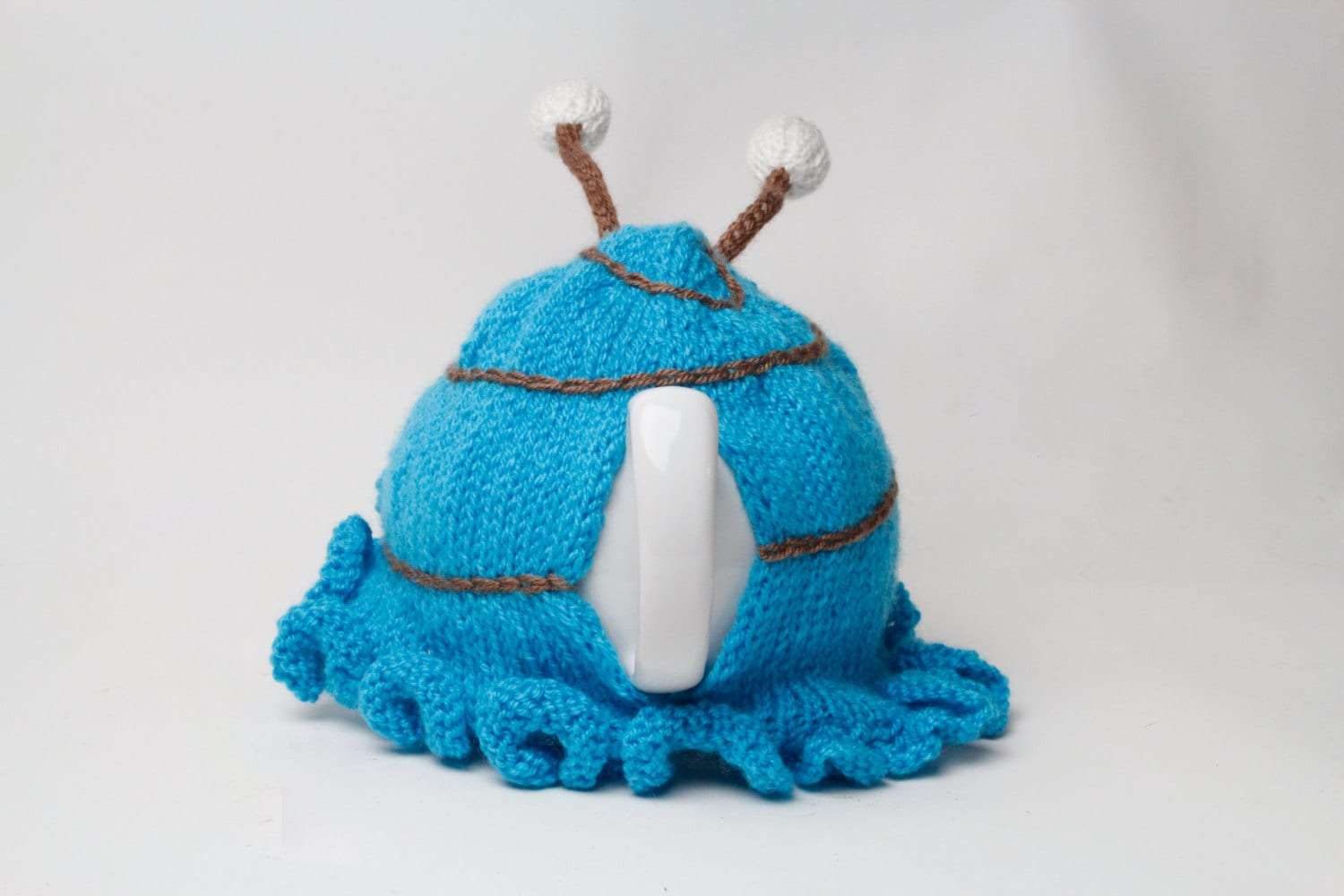 Hand knitted blue snail tea cosy with frilly bottom and boggly eyes.  Fits 6 cup and 2 cup pots.