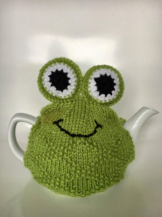 Green frog hand knitted tea cosie with large padded eyes.