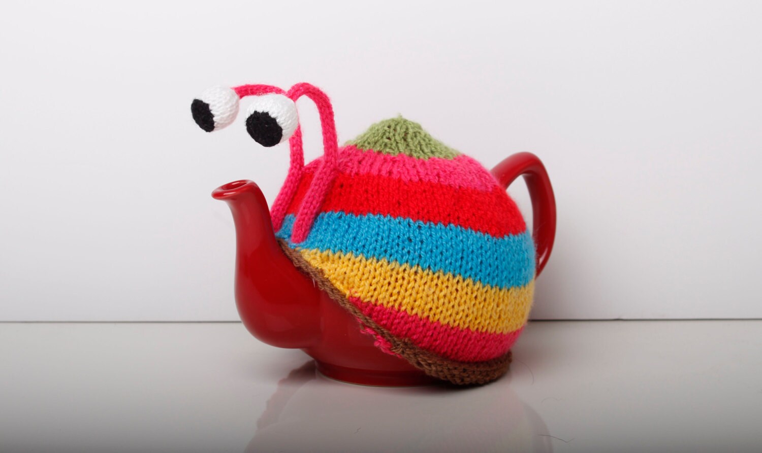 Knitted pink stripy snail tea cosy. Tea lovers teatime treat.