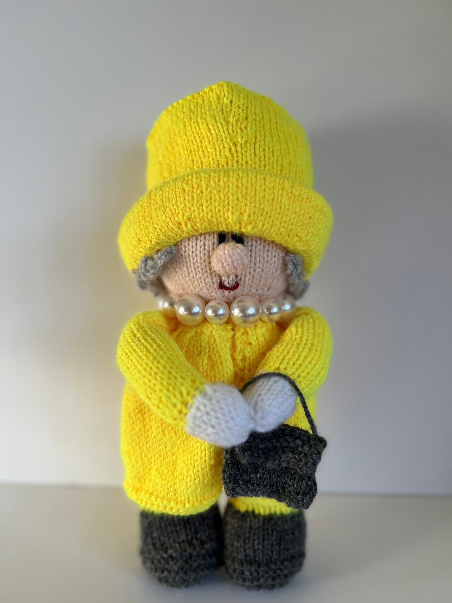 Queen Elizabeth II hand knitted character available in a variety of colours. Handbag on left or right with accessories …