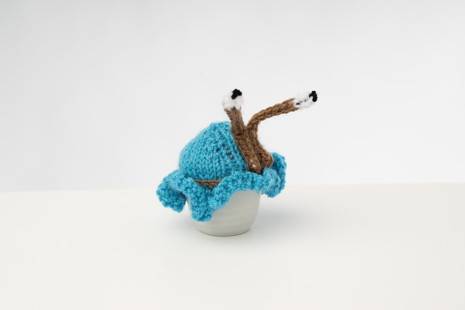 Hand knitted blue snail tea cosy with frilly bottom and boggly eyes.  Fits 6 cup and 2 cup pots.