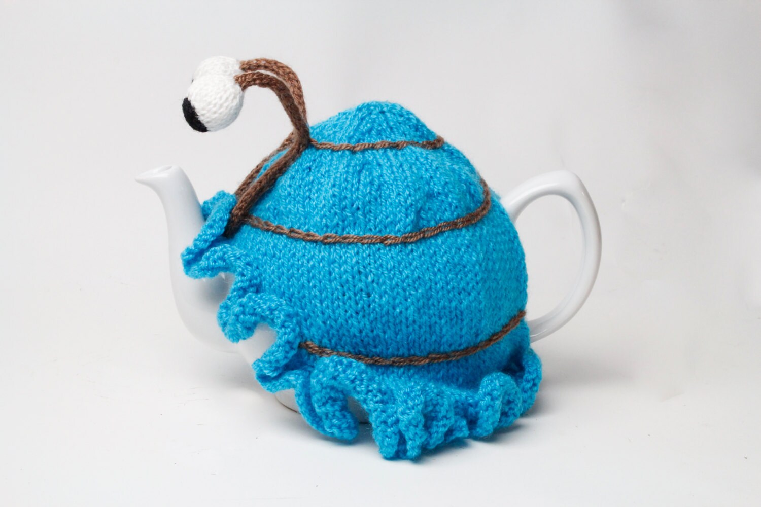 Hand knitted blue snail tea cosy with frilly bottom and boggly eyes.  Fits 6 cup and 2 cup pots.