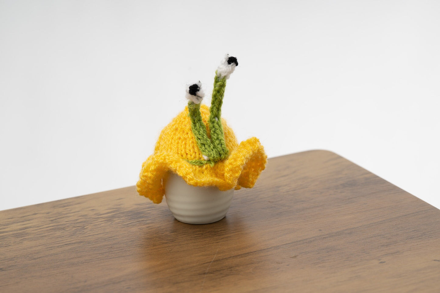 Knitted yellow snail tea cosy with frilly bottom. 6 cup and 2 cup sizes. Washable.